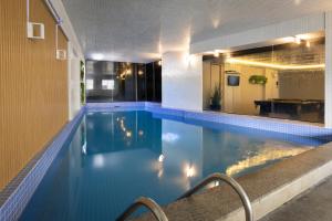 a swimming pool with blue water in a building at Camboriú Praia Hotel in Balneário Camboriú