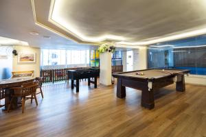 a room with a pool table and some tables at Camboriú Praia Hotel in Balneário Camboriú