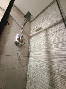 a shower in a bathroom with a tile wall at Vivienda 01 Appartement moderne au cœur de Mohammedia , Calme et Confort in Mohammedia +25 photos