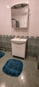 a bathroom with a sink and a mirror and a blue rug at Iranija 21 in Daugavpils +14 photos