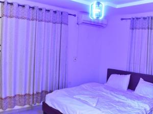 a bedroom with purple curtains and a large bed at Skye Palace Apartment - Skye Regency 2 Bedroom Apartment in Akure
