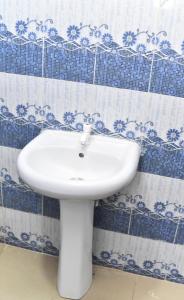 a white sink in a bathroom with blue and white tiles at Skye Palace Apartment - Skye Regency 2 Bedroom Apartment in Akure