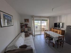 a living room with a couch and a table at T2 Château vert in Le Grau-dʼAgde