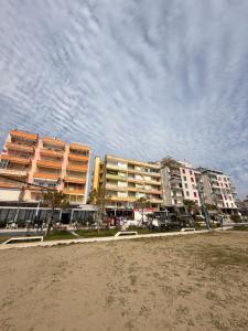 two tall buildings on the beach with a cloudy sky at Beachfront Apartment Durres in Durrës
