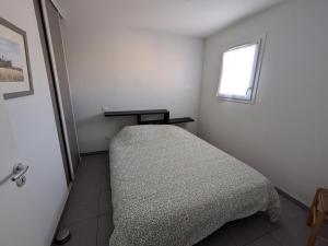 a bed in a room with a window at T2 Château vert in Le Grau-dʼAgde
