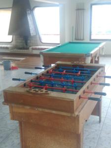 a room with two tables and a pool table at De Rose Centro Hotel in Torres