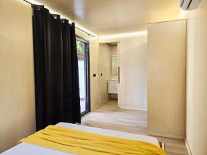 a bedroom with a bed and a large window at Camping Costa Dorada Tiny Amaia in Canet de Mar
