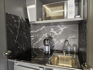 a kitchen counter with a sink and a microwave at Camping Costa Dorada Tiny Amaia in Canet de Mar