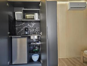 a small kitchen with a sink and a microwave at Camping Costa Dorada Tiny Amaia in Canet de Mar