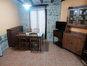 a dining room with a table and a television at CASA VICENT in Valderrobres