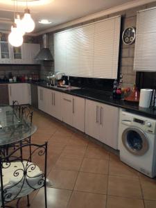 a kitchen with a washing machine and a table at Villa Oasis Ain El Turk in Aïn El Turk