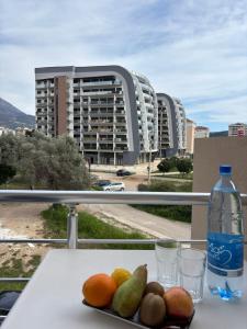 a plate of fruit on a table with a bottle of water at Villa Cherry in Bar