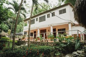 a house in the middle of a garden at Manigua Tayrona Hostel in Santa Marta