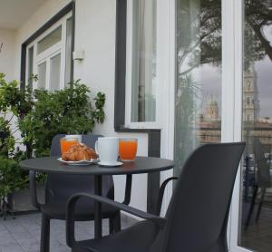 a table with a plate of food and two chairs at Residenza Madonna in Pompei
