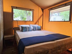 a bedroom with a bed with two pillows and a window at Camping Costa Dorada Tienda Lua in Canet de Mar +14 photos