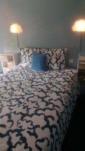 a bedroom with a bed with a blue pillow and two lamps at Relais de Bénévent in Bénévent-lʼAbbaye