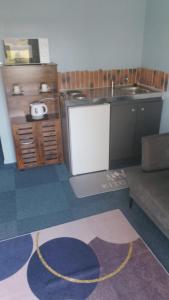 a kitchen with a refrigerator and a sink and a couch at Relais de Bénévent in Bénévent-lʼAbbaye