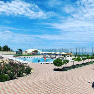 a swimming pool with chairs and umbrellas in a resort at Anna Mariya Villa in Kurortne