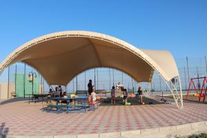 a group of people standing under a pavilion at a playground at Anna Mariya Villa in Kurortne