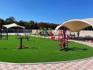 a playground with a play area with green grass at Anna Mariya Villa in Kurortne