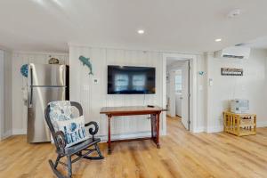 a room with a chair and a table and a refrigerator at Cool Change in Hampton