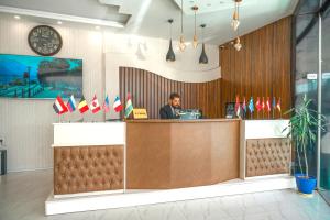 a man sitting at a counter in a restaurant with flags at Hotel Danzha2 Erbil in Erbil
