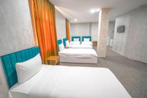 a hotel room with two beds with blue and white at Hotel Danzha2 Erbil in Erbil