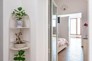 a hallway with a mirror and a room with a bed at La casetta di pami- Enjoy Apulia in Monopoli +7 photos