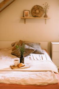 a bed with a plate of bread and a cup of coffee at Domek SzumiSosna2 in Życiny