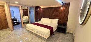a hotel room with a bed and a mirror at Hotel Olimpica Boutique in Mexico City