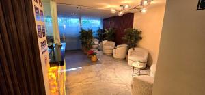 a lobby with a waiting room with chairs and plants at Hotel Olimpica Boutique in Mexico City