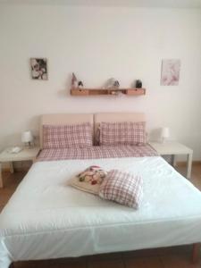 ein Bett mit zwei Kissen und einem Baby darauf in der Unterkunft Le Laite in Conco