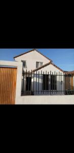a white house with a gate and a building at Isabel de la serena in La Serena