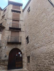 an old stone building with a door and a balcony at CASA VICENT in Valderrobres