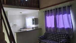 a living room with a purple curtain and a couch at Cabana centro Pinhal in Santo Antônio do Pinhal
