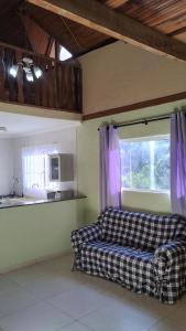 a living room with a couch and a window at Cabana centro Pinhal in Santo Antônio do Pinhal