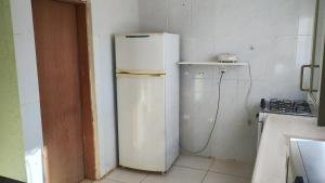 a kitchen with a white refrigerator in a room at Cabana centro Pinhal in Santo Antônio do Pinhal