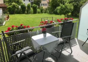 a table and chairs on a balcony with flowers at Apartments Reischl in Bergkirchen