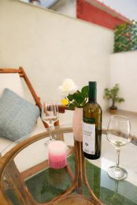 a glass table with a bottle of wine and two glasses at Studio with Patio - 3 min Walk to Beach - Diamond 2 in Kardamaina +11 photos