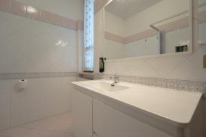 a white bathroom with a sink and a mirror at Appartamento indipendente in villa a Casalpusterlengo in Casalpusterlengo