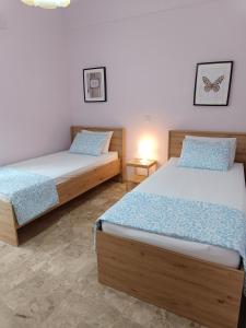 a bedroom with two beds and a night stand at Plateia Home in Karditsa