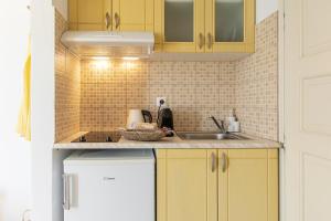 a kitchen with yellow cabinets and a sink at Sunshine in Naxos Chora +125 photos
