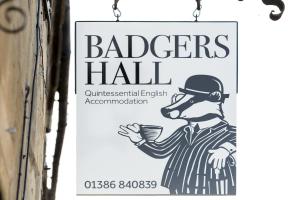 una señal colgando en un lado de un edificio sosteniendo una taza en Badgers Hall en Chipping Campden