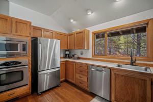 a kitchen with wooden cabinets and stainless steel appliances at 61 Wildflower in Sunriver