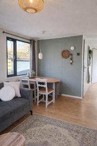 a living room with a couch and a table at Sfeervol Chalet - Gelegen In bosrijkgebied van Drenthe - Rust en Natuur in Eext