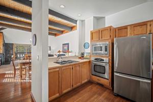 a kitchen with wooden cabinets and a stainless steel refrigerator at 61 Wildflower in Sunriver