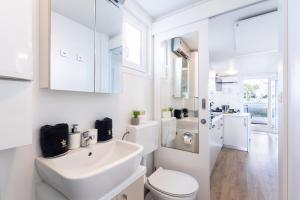 a white bathroom with a sink and a toilet at Floating House Royal Blue Portorož in Portorož