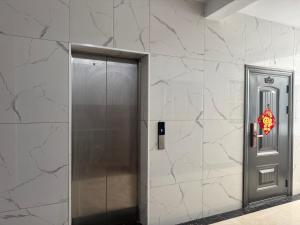 a metal elevator with a door on a wall at 海客瀛洲 Haïke-Îlezone in Abidjan