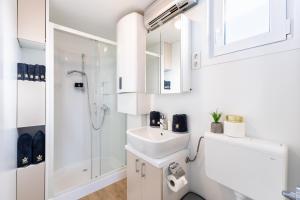 a white bathroom with a sink and a shower at Floating House Royal Blue Portorož in Portorož