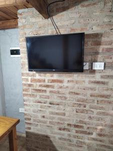 a flat screen tv hanging on a brick wall at La Damasca 1 in General Roca